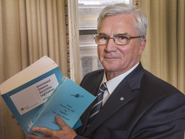 Thomas Caldwell, chairman and CEO, Caldwell Securities, speaks to the Empire Club of Canada's 19th Annual Investment Outlook luncheon, in Toronto, Ontario, Canada, on Thursday, January 3, 2013.  Caldwell, who used the opportunity to attack over-regulation of the securities industry, holds two copies of the Ontario Securities Act, one a small book from the 80's and the newest edition, bigger than a phonebook. photographer: Norm Betts