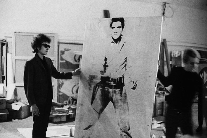 Bob Dylan holding a Double Elvis print at The Factory